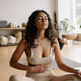 Une femme assise est assise en tailleur et respire profondément