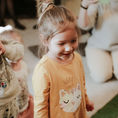 Une petite fille au milieu des enfants sourit
