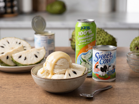 Bowl of soursop ice cream with condensed milk, beside Jans guanabana and Sweet Cow cans, on a kitchen table with sliced soursop.