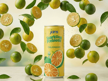 A yellow can of Jans Sparkling Prebiotic Calamansi drink surrounded by floating whole and halved green calamansi fruits with fresh leaves.