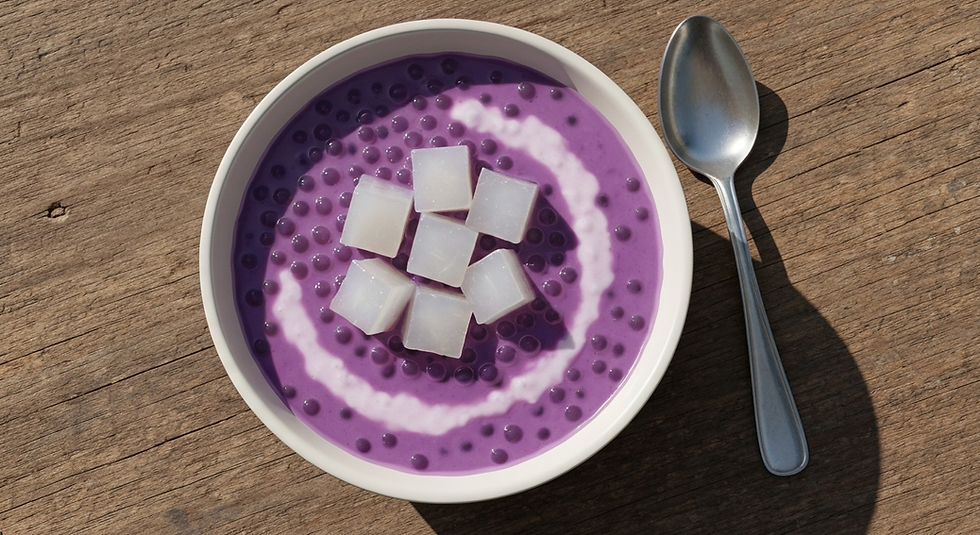 A bowl of creamy purple ube sago dessert, topped with coconut jelly cubes and a spoon.