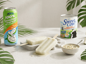 Two creamy soursop popsicles on a tray next to a can of Jans 100% Guanabana Juice and a can of Sweet Cow Sweetened Condensed Creamer.
