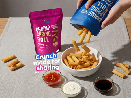 Hands pouring bite-sized Jans Shrimp Spring Rolls into a bowl, surrounded by pink and blue snack bags and three different dipping sauces on a light gray mat.
