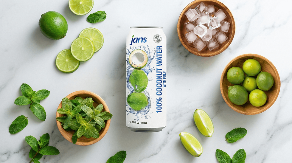 A white can of Jans 100% Coconut Water with Pulp surrounded by fresh lime slices, mint leaves, and bowls of ice and whole limes on a white marble surface.