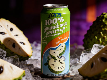 A green can of Jans 100% Guanabana Soursop Juice surrounded by sliced open fresh soursop fruits showing their black seeds, nestled on a bed of ice cubes against a dark purple background.