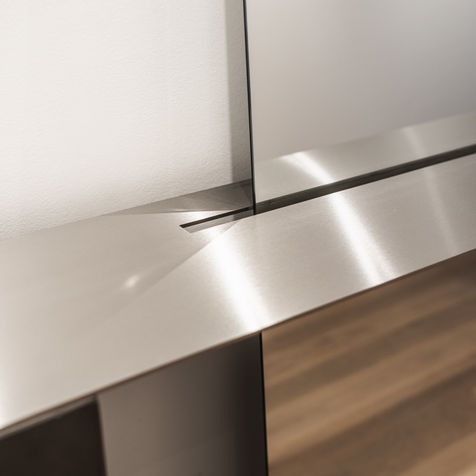 custom design sideboard with integrated mirror, made from thick stainless steel with laser cutouts and concrete blocks. Designed by case studios