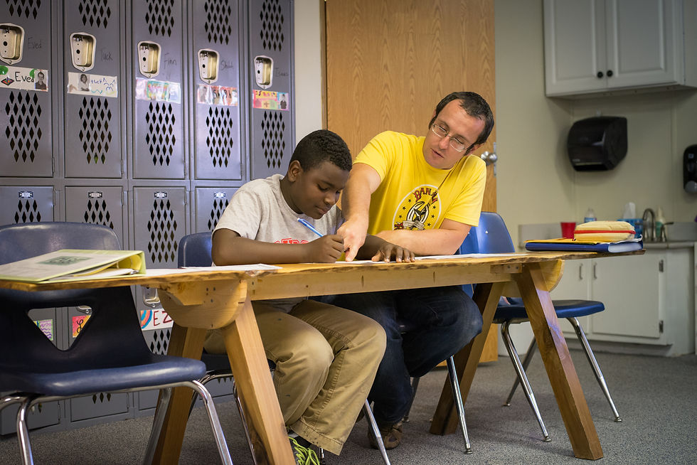 Brandon Galford, a teacher at both the Institute and the Academy for G.O.D., tutors Yancey with his math homework. Yancey and his family live directly across from our headquarters, and he has enjoyed being involved in all of our summer camps and aft…