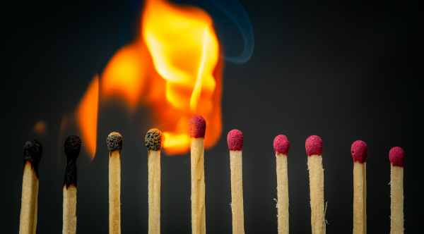 A row of matches in sequence — some burned, one actively igniting, the rest unlit — against a dark background, illustrating the chain reaction moment when accumulated complexity tips a Salesforce system past its governor limits.
