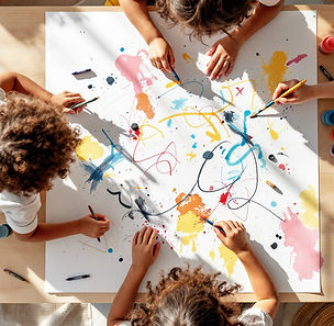 Children exploring open-ended mark-making with crayons, paint, and brushes while creating colorful lines, swirls, dots, and patterns on a large shared sheet of paper during a preschool process art activity.