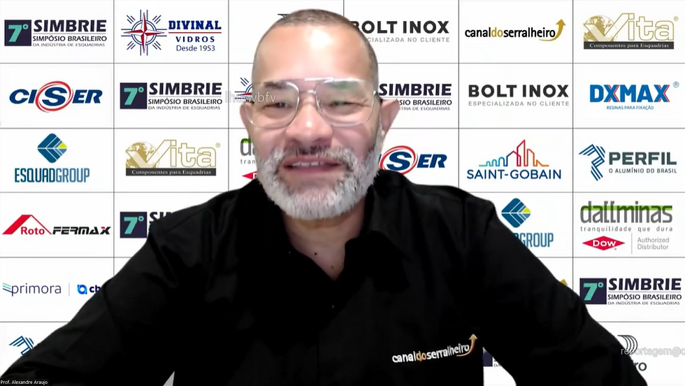 Homem de camisa preta em evento online com fundo de logos de empresas