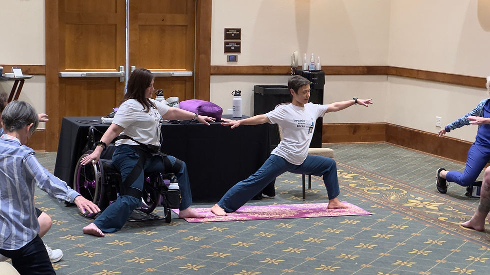 Image is of Vera and Deborah instructing yoga, one in a wheelchair and one person standing. Both are in the warrior pose