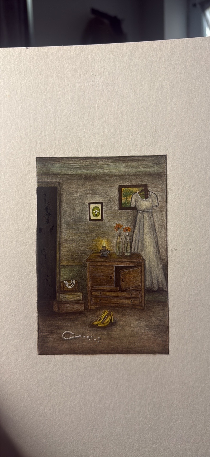 Mudy tilted ways by Aqsa Latif, depicts a dimly lit room with a wooden cabinet and orange flowers
