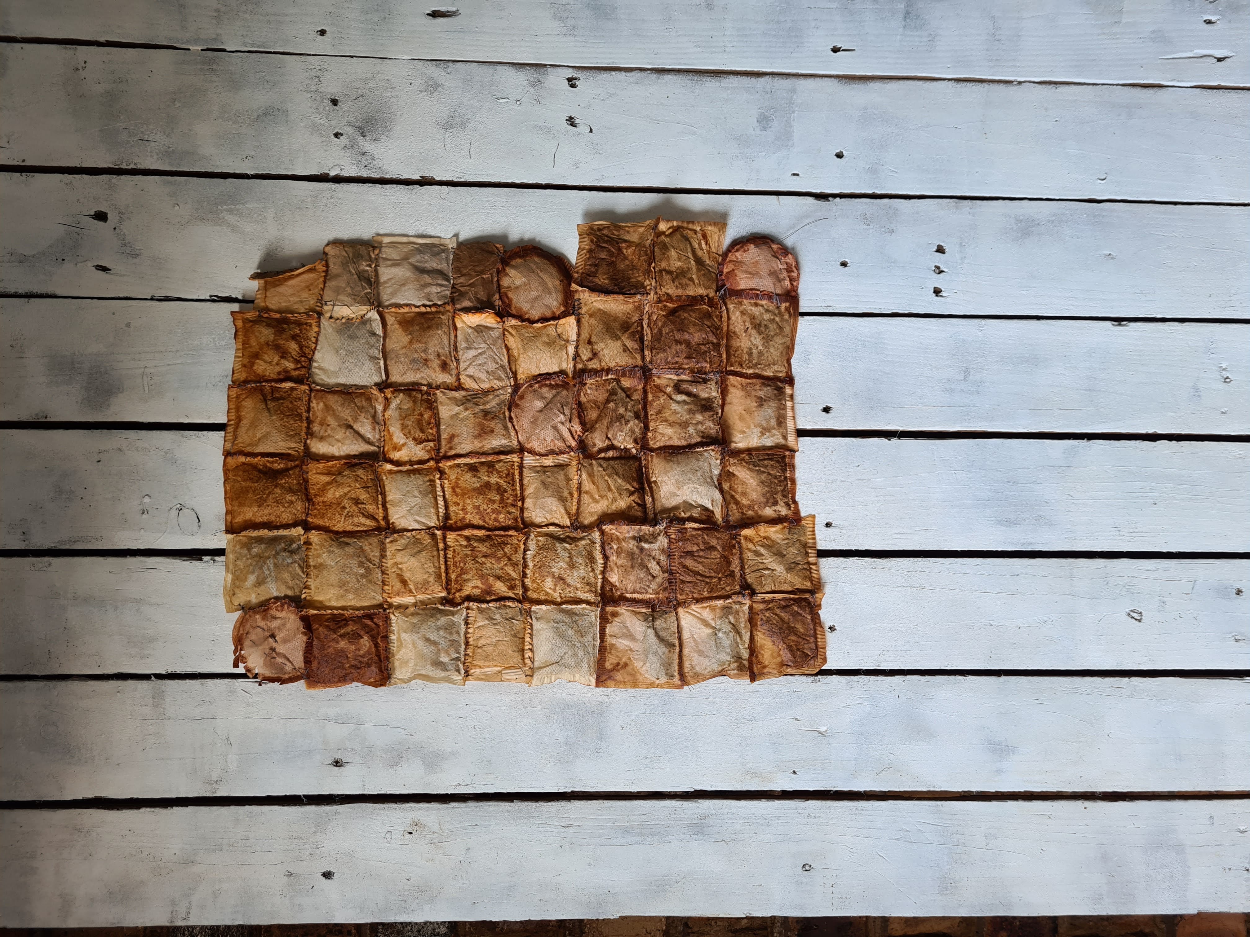 Conversations by Karla britz, grid of stitched tea bags on wood