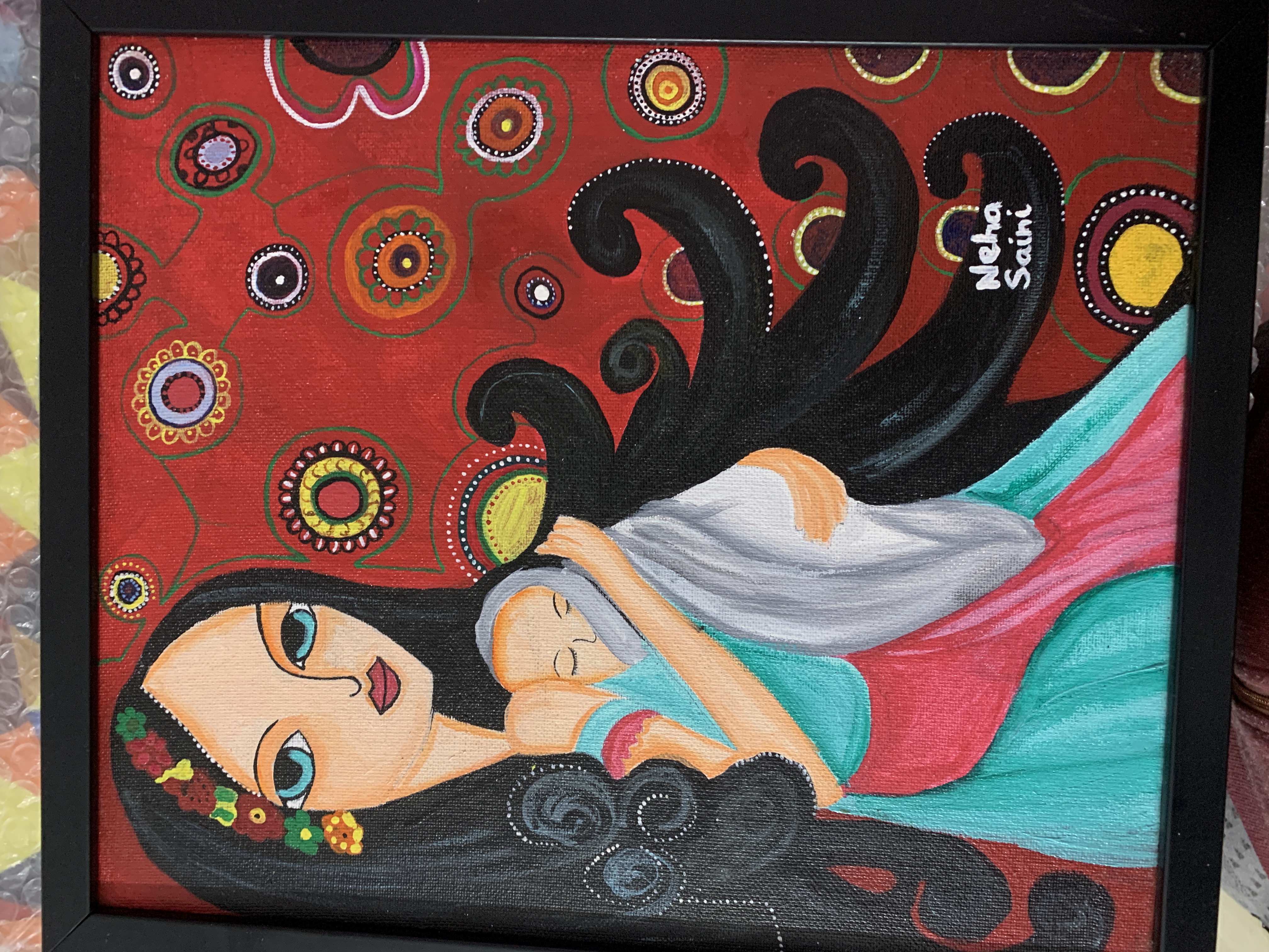 Motherhood by Neha Saini, a mother holding her child with expressive eyes and colorful flowers