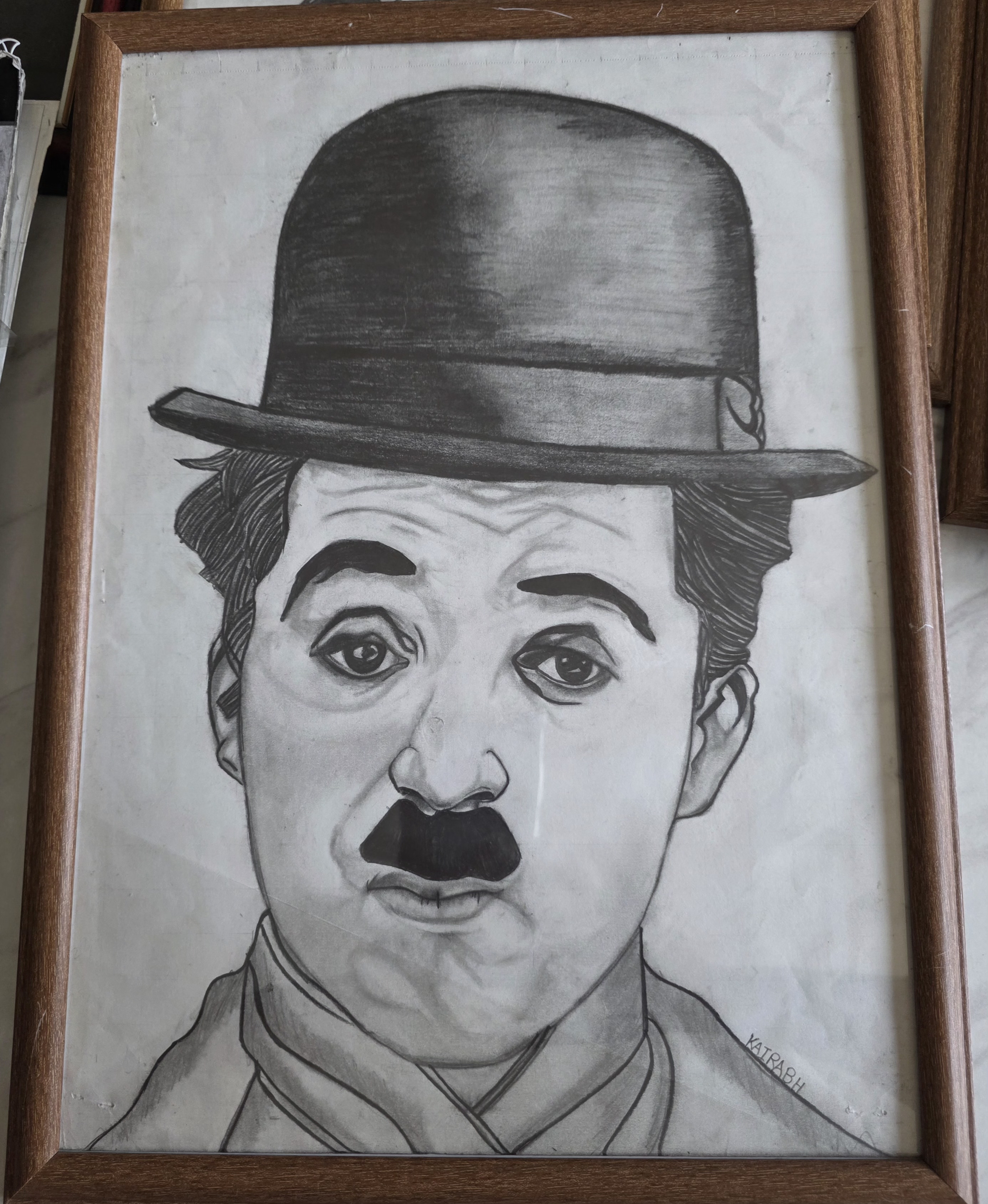 The Silent Smile by Kairabh Kaware, a detailed charcoal portrait of a silent film comedian