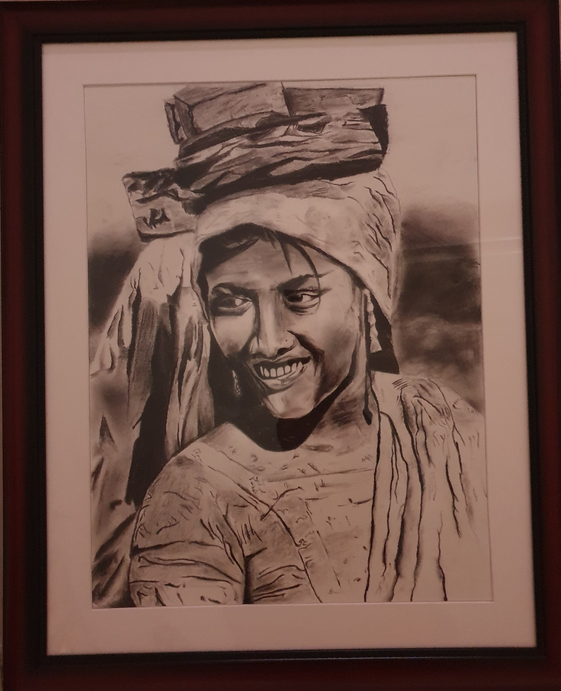 Smiles of Labor by Bhargav Chandrasekar, monochrome portrait of a smiling woman with a headscarf carrying bricks