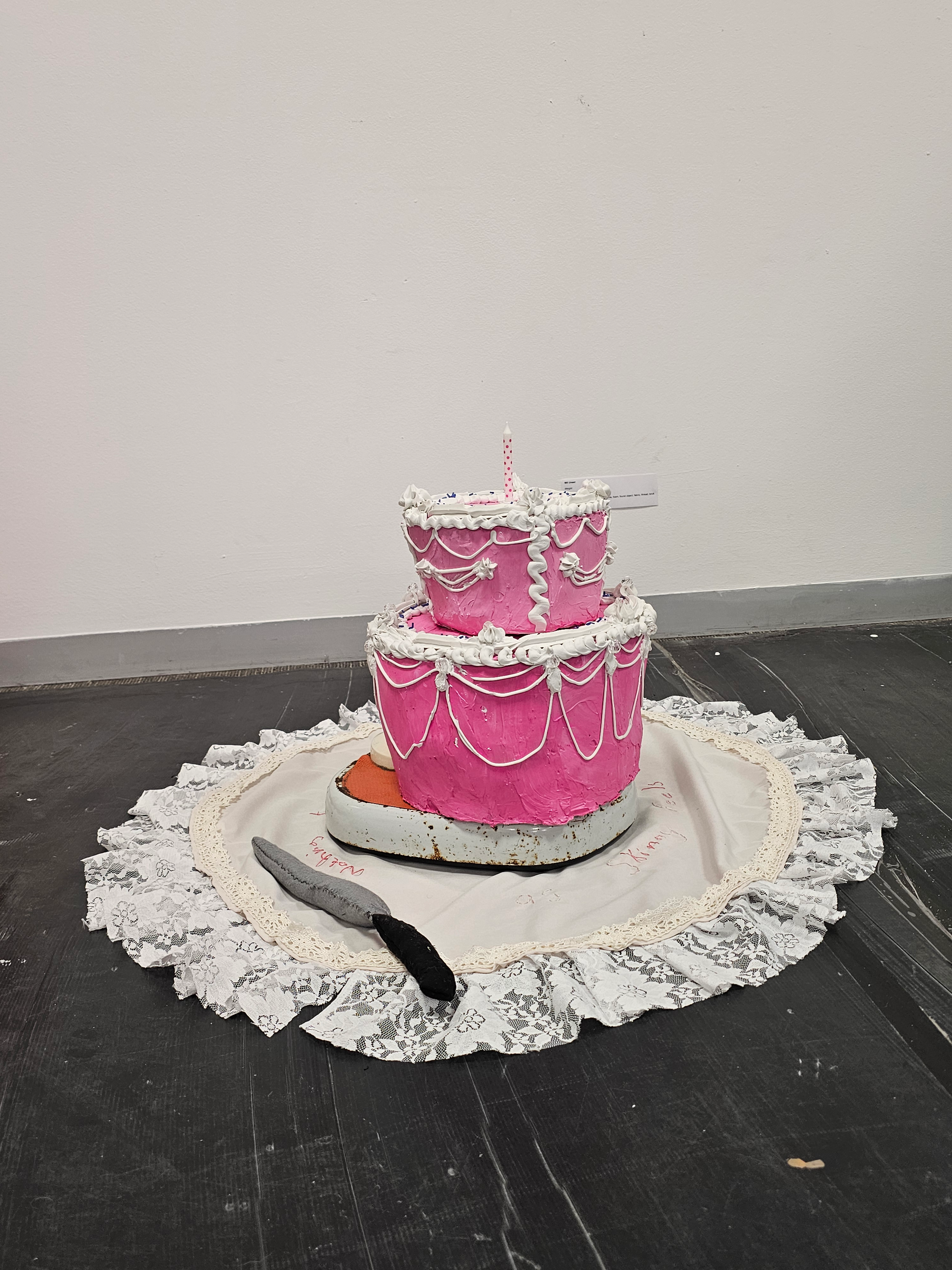Weight by Wil Unser, pink cake sculpture with intricate white icing details and a candle