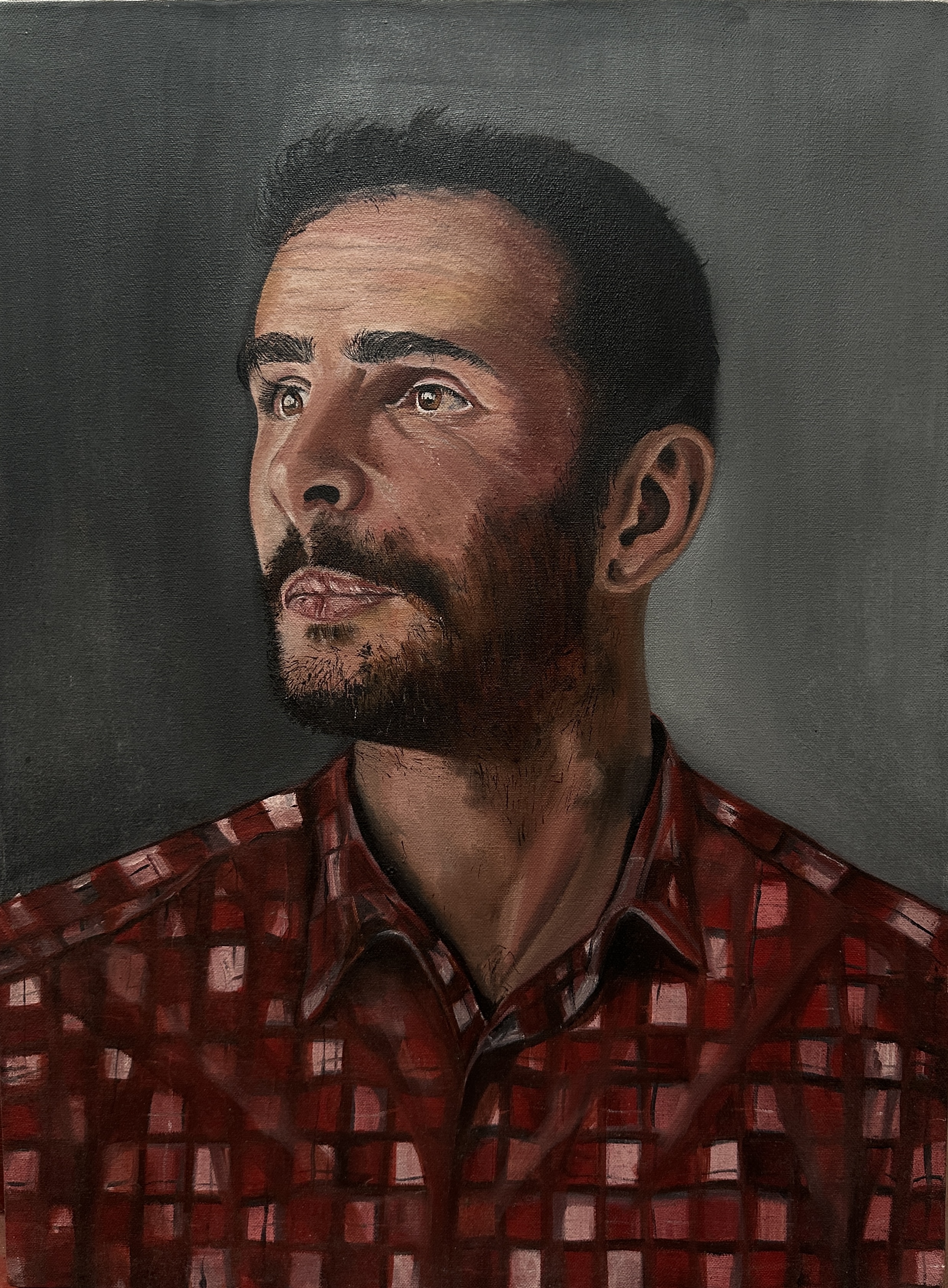 Portrait by Ashraff mohamed Aaisha, a contemplative man gazing with a red plaid shirt
