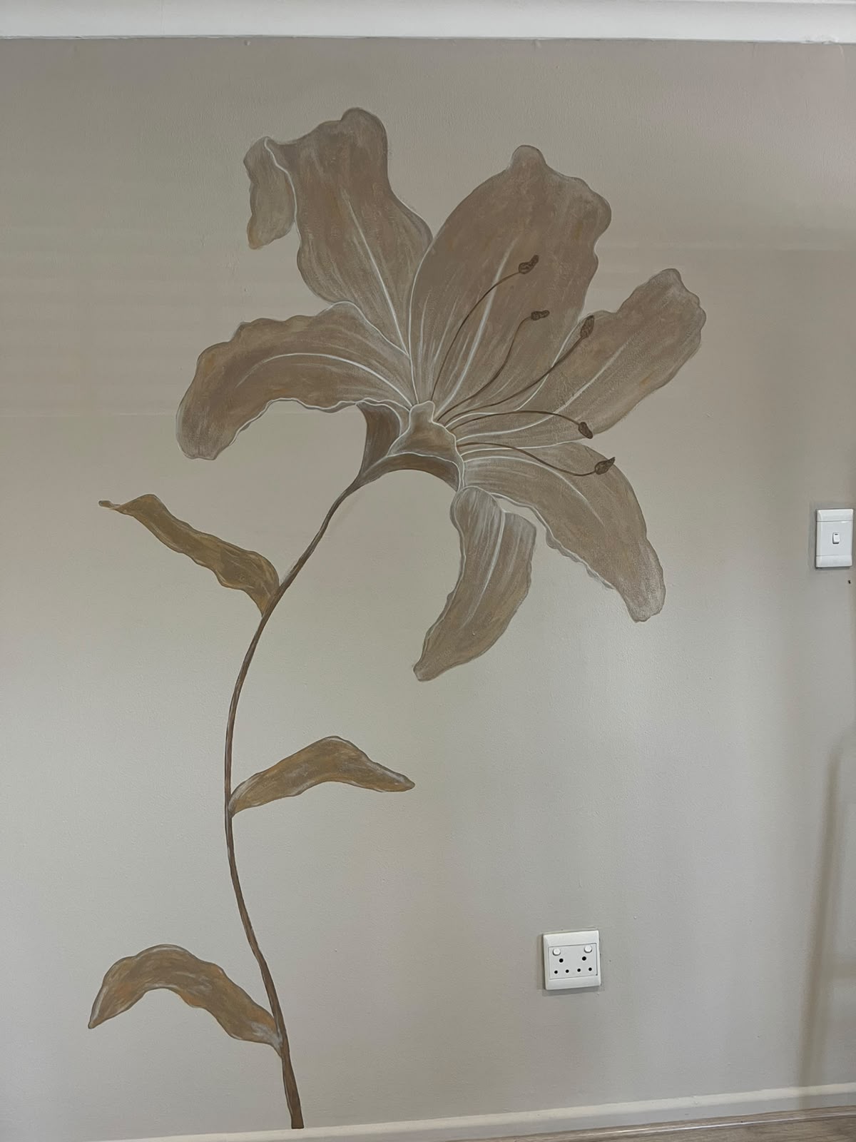 Autumn Lily by Amke Visagie, a large brown and beige lily painted on a wall