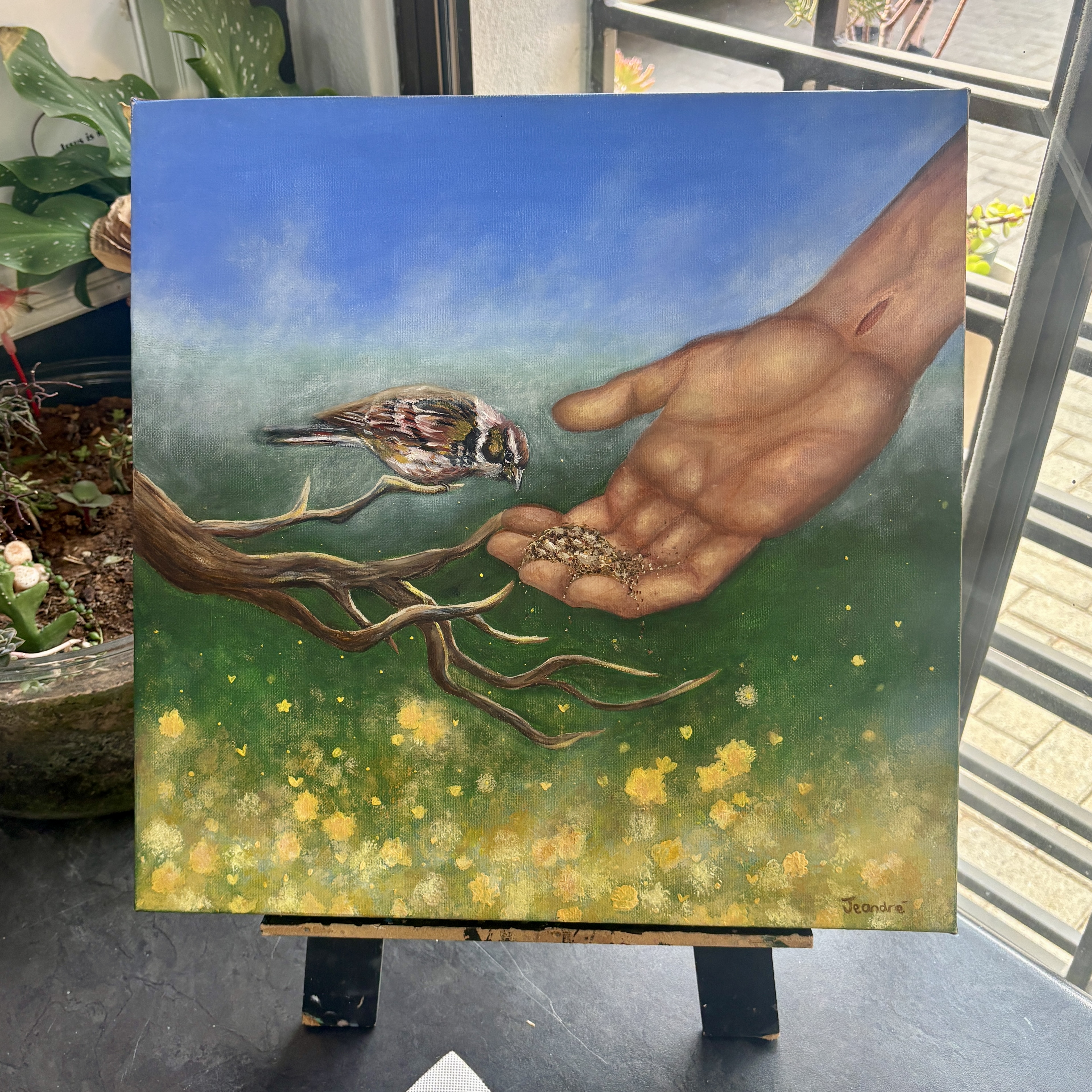 Provider by Jeandre - a hand offering seeds to a bird against a gradient sky