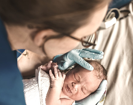 midwife assessing a newborn baby
