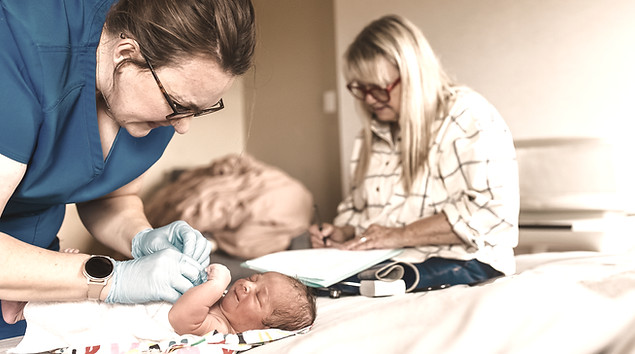 midwife taking of a newborn baby