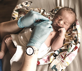 midwife assessing a newborn baby