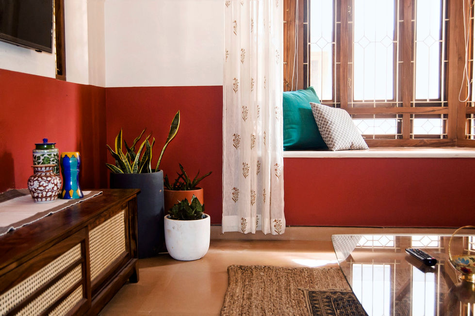 a living room with red walls and white curtains