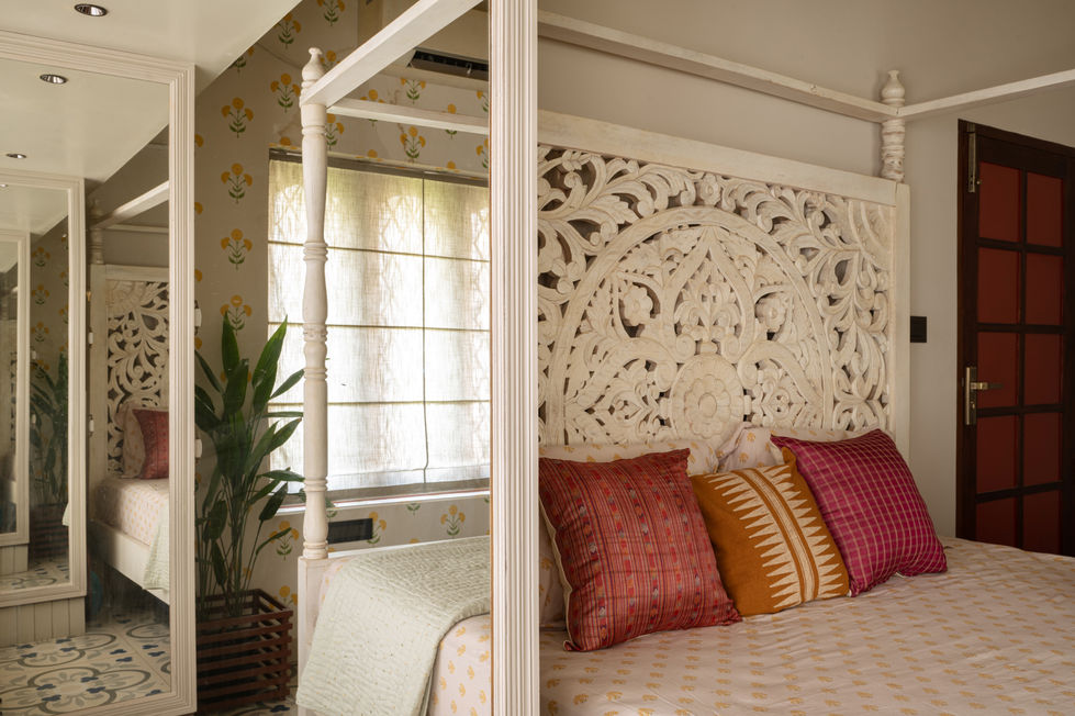 a bedroom with a canopy bed and a carved headboard