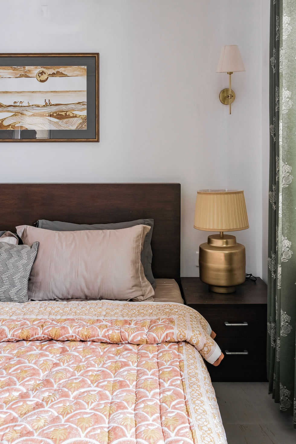 a bed with a lamp and a picture on the wall above it