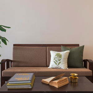 a stack of books on a table next to a brown couch
