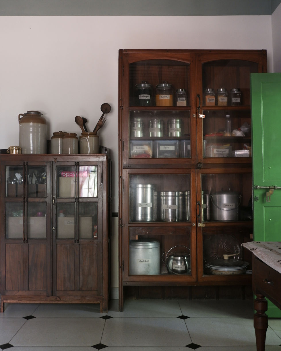 a wooden cabinet filled with jars including one that says ' cumin ' on it