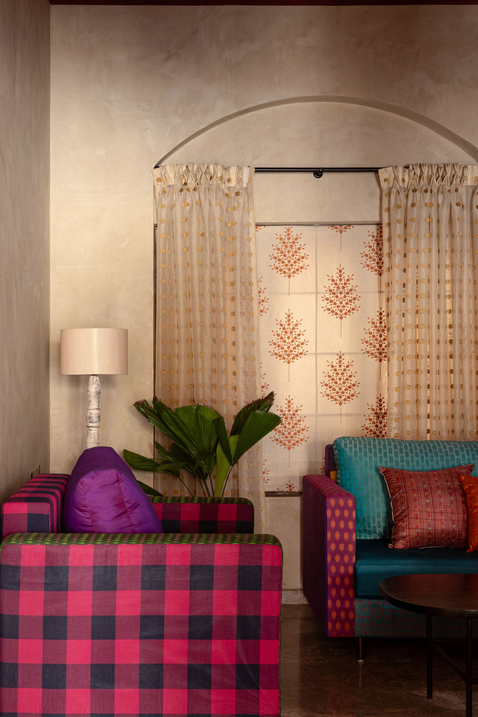 a living room with colorful furniture and a lamp