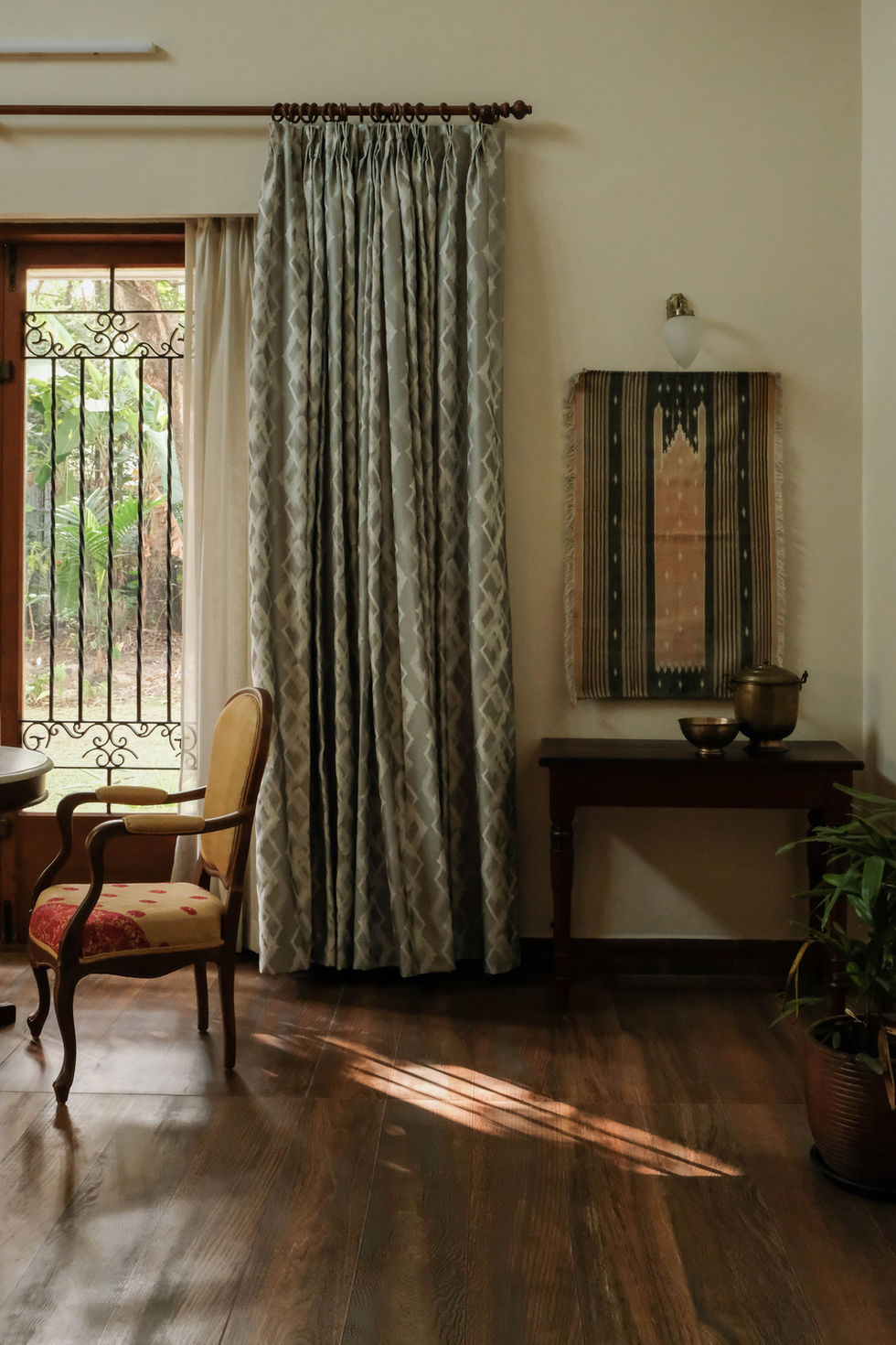 a room with a chair a table and a painting on the wall