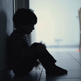 Student sitting alone in school corridor highlighting adolescent mental health concerns 