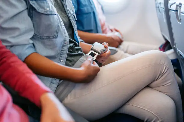 Passengers wearing seat belts inside airplane cabin during flight