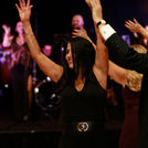 Guest enjoying a luxury Houston event celebration while dancing to Grupo KaChe live entertainment, with the band performing in the background.