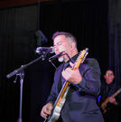 Grupo KaChe guitarist, vocalist, and harmonica player performing live at a Houston event venue featuring country music, Top 40 hits, and Latin favorites.