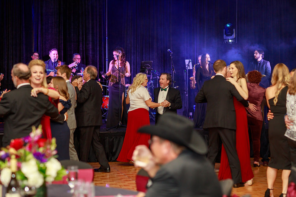 Guests dance and celebrate at a luxury Houston event while Grupo KaChe performs live in the background, bringing energy and live entertainment to the celebration.