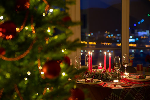 beautifully decorated Christmas table with candles and glasses near the Christmas tree.jpg