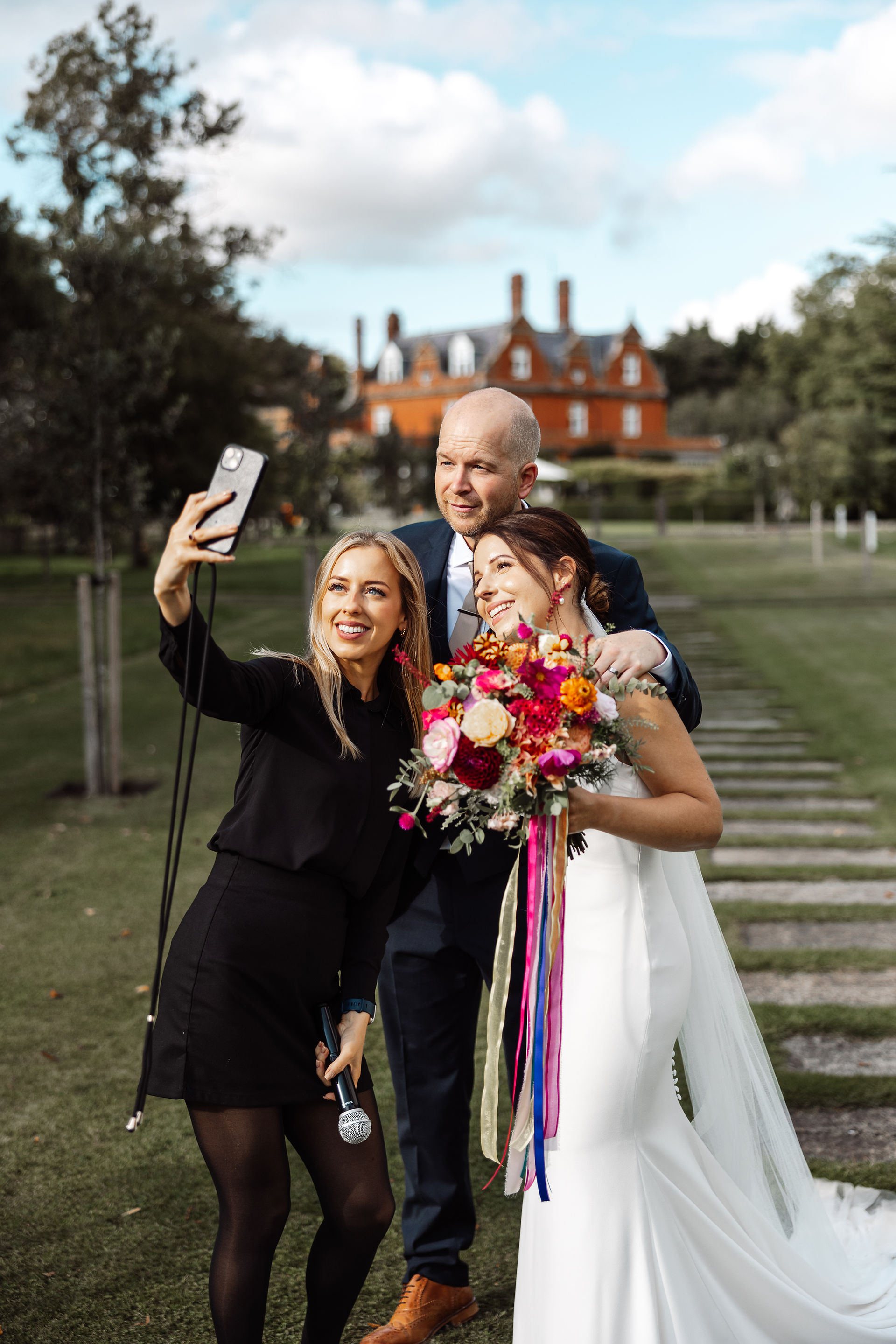 Wedding Manager, Beccy, poses with newlyweds in the garden ©jamie stone photography