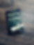 Book titled "Phantom Algebra" by Dan Rice on wood surface. Cover shows eerie library, ghostly green hand writing. Spooky mood.