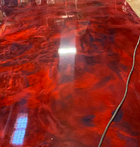 Bright red metallic epoxy floor with a glossy reflective finish