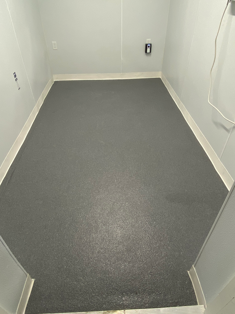 Gray coated floor in an empty white basement room