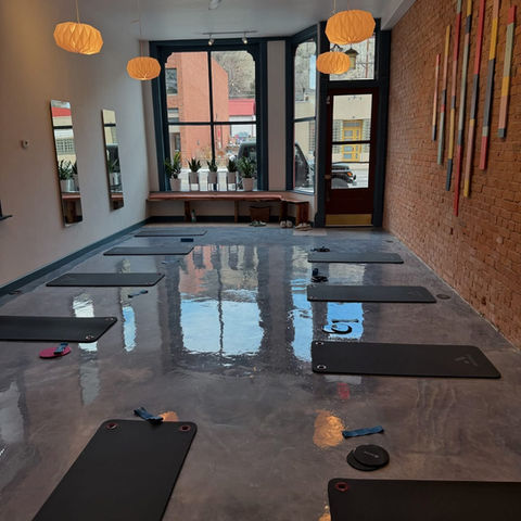 Metallic epoxy studio floor with yoga mats and brick walls
