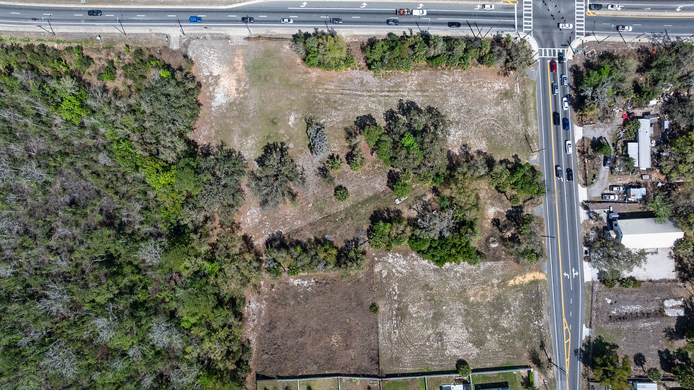 Aerial view of undeveloped land with roads and homes