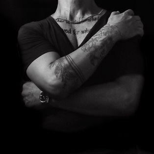a mans chest with many tatoos in black and white