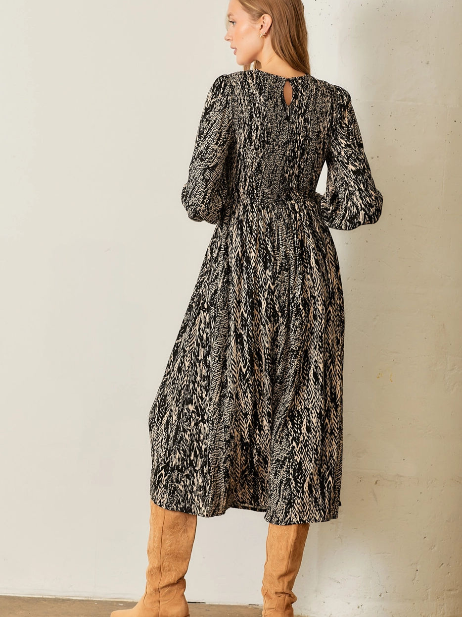 Thumbnail: Woman wearing long sleeve patterned dress. Elegant fashion-forward outfit.