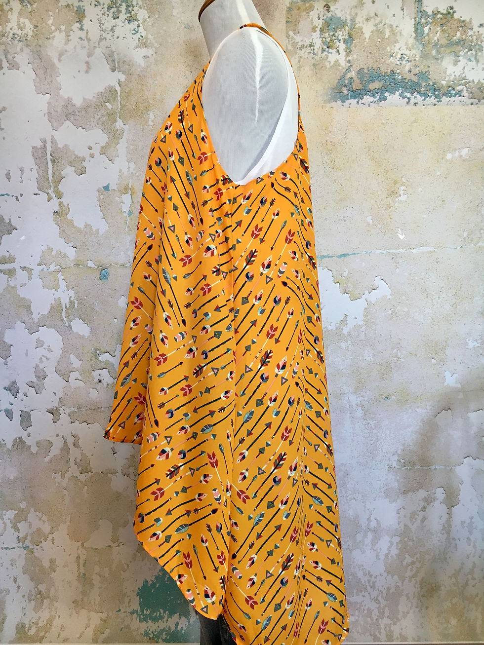 Thumbnail: Yellow patterned dress with arrows displayed on a mannequin, in front of wall.