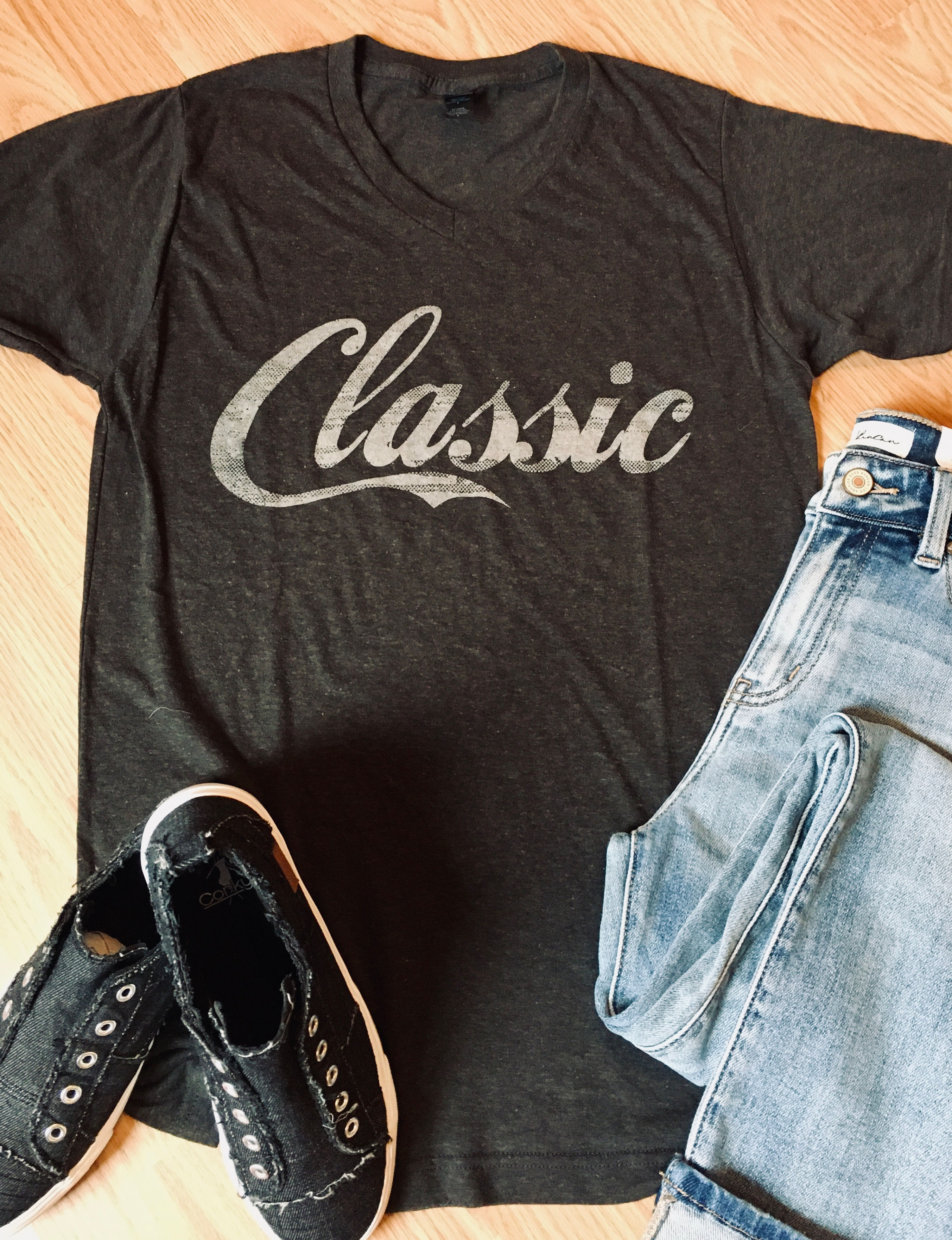 Gray Classic t-shirt with jeans and black shoes on wooden surface